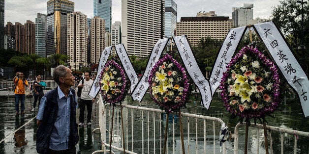 HONG KONG - JUNE 04: People walk past flowers at Victoria Park before the candlelight vigil on June 4, 2016 in Hong Kong, Hong Kong. Thousands of people in Hong Kong participated in an annual candlelight vigil in Hong Kong on June 4 to commemorate the killing of protesters in Beijing's Tiananmen Square in 1989. (Photo by Lam Yik Fei/Getty Images)