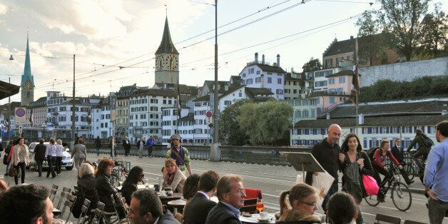 People at a street cafe in front of the town hall at Limmat river, Zurich, Switzerland, Europe
