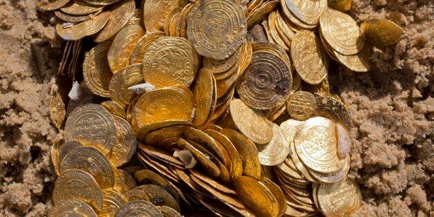 This photo shows a detail of Fatimid period gold coins that were found in the seabed in the Mediterranean Sea near the port of Caesarea National Park in Caesarea, Israel, Wednesday, Feb. 18, 2015. A group of amateur Israeli divers have stumbled upon the largest collection of medieval gold coins ever found in the country, dating back to the 11th century and likely from a shipwreck in the Mediterranean Sea. (AP Photo/Ariel Schalit)