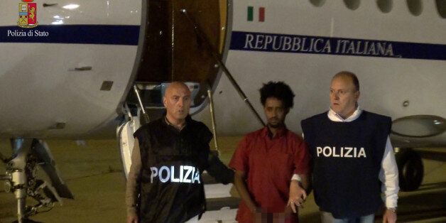 Medhanie Yehdego Mered (C), 35, is pictured with Italian policemen as they land at Palermo airport, Italy, following his arrest in Khartoum, Sudan, on May 24. Picture released on June 8, 2016 by Italian Police Department. Image pixellated at source. Italian Police Department/Handout via REUTERS ATTENTION EDITORS - THIS IMAGE WAS PROVIDED BY A THIRD PARTY. EDITORIAL USE ONLY TPX IMAGES OF THE DAY.