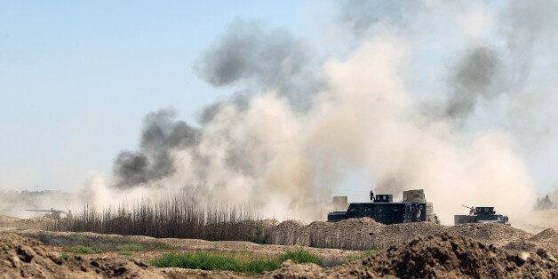 Smoke billows in the background as Iraqi government forces advance near al-Sejar village, north-east of Fallujah, on May 26, 2016, as they take part in a major assault to retake the city from the Islamic State (IS) group.Tens of thousands of security forces are deployed in the Fallujah area for an assault aimed at retaking the city from the Islamic State group.Fallujah, which lies only 50 kilometres (30 miles) west of Baghdad, has been out of government control since January 2014 and is one of only two remaining major Iraqi cities still in IS hands, the other being Mosul. / AFP / AHMAD AL-RUBAYE (Photo credit should read AHMAD AL-RUBAYE/AFP/Getty Images)