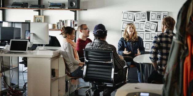 Businesswoman leading project meeting with coworkers in high tech startup office