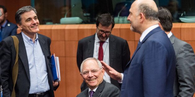 Germany's Finance Minister Wolfgang Schauble center, talks with EU Commissioner for Economic and Financial Affairs, Taxation and Customs Pierre Moscovici, right, and Greece's Finance Minister Euclid Tsakalotos during the Eurogroup finance ministers meeting at the EU Council building in Brussels on Thursday, Feb. 11, 2016. (AP Photo/Geert Vanden Wijngaert)