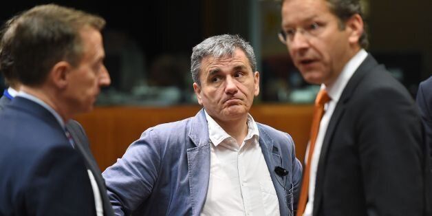 Greece's Finance Minister Euclid Tsakalotos (C) and Eurogroup President and Dutch Finance Minister Jeroen Dijsselbloem (R) attend an Economic and Financial (ECOFIN) Affairs Council meeting at the European Council, in Brussels, on May 25, 2016. / AFP / EMMANUEL DUNAND (Photo credit should read EMMANUEL DUNAND/AFP/Getty Images)