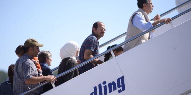 A group of Syrian refugees board a plane with Pope Francis on April 16, 2016 at the airport of Mytilene, in the Greek island of Lesbos. Twelve Syrian refugees were accompanying Pope Francis on his return flight to Rome after his visit to Lesbos on Saturday and will be housed in the Vatican, the Holy See said. 'The pope has desired to make a gesture of welcome regarding refugees, accompanying on his plane to Rome three families of refugees from Syria, 12 people in all, including six children,' a Vatican statement said. AFP PHOTO POOL / FILIPPO MONTEFORTE / AFP / POOL / FILIPPO MONTEFORTE (Photo credit should read FILIPPO MONTEFORTE/AFP/Getty Images)