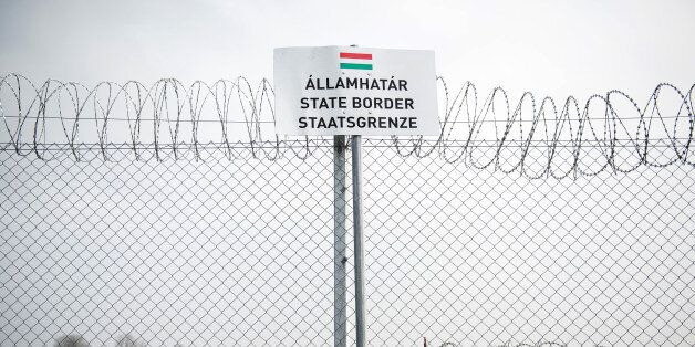 A sign sits beside a razor wired topped security fence on the Hungarian-Serbian border near Roszke, Hungary, on Wednesday, Feb. 17, 2016. The European Union is 'defenseless' against mass migration from the Middle East and the inflow of refugees constitutes the 'most serious issue' the 28-nation trading bloc has faced since its founding, according to Hungary's minister of foreign affairs and trade Peter Szijjarto. Photographer: Akos Stiller/Bloomberg via Getty Images