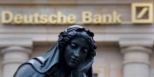 A statue is seen next to the logo of Germany's Deutsche Bank in Frankfurt, Germany, January 26, 2016. REUTERS/Kai Pfaffenbach/File Photo