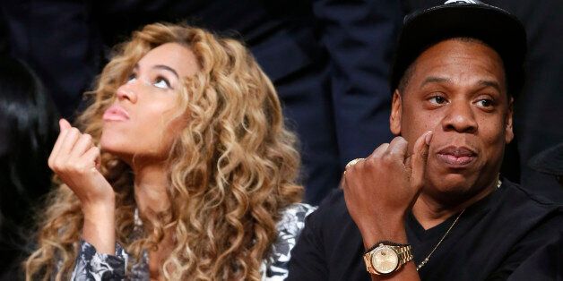 Singer Beyonce and her husband Jay-Z sit courtside before the NBA All-Star basketball game in Houston, Texas, February 17, 2013. REUTERS/Lucy Nicholson (UNITED STATES - Tags: SPORT BASKETBALL)