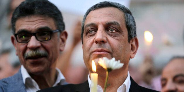 In this Tuesday, May 24, 2016 picture, Yahia Kalash, the head of journalists' union, holds a candle during a candlelight vigil for the victims of EgyptAir flight 804 in front of the Journalists' Syndicate in Cairo, Egypt. The head of Egyptâs journalists union and two of its board members have been questioned by prosecutors over allegations that they harbored journalists wanted by authorities and spreading false news, one of the three and their lawyer said on Monday. (AP Photo/Amr Nabil)