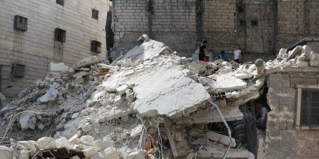 ALEPPO, SYRIA - MAY 17: People inspect the debris of collapsed buildings after Assad Regime's attack with a highly-explosive local-made missile called the Elephant over residential areas in opposition controlled Sukeri neighborhood of Aleppo, Syria on May 17, 2016. Several casualties reported. (Photo by Ibrahim Ebu Leys/Anadolu Agency/Getty Images)