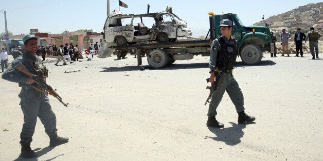 Afghanistan security forces inspect the site of a suicide attack in west Kabul, Afghanistan, Wednesday, May 25, 2016. A suicide bomber targeted a vehicle carrying court employees in Kabul during morning rush hour on Wednesday, killing several people, an Afghan official said. The Taliban claimed responsibility for the attack. (AP Photo/Massoud Hossaini)