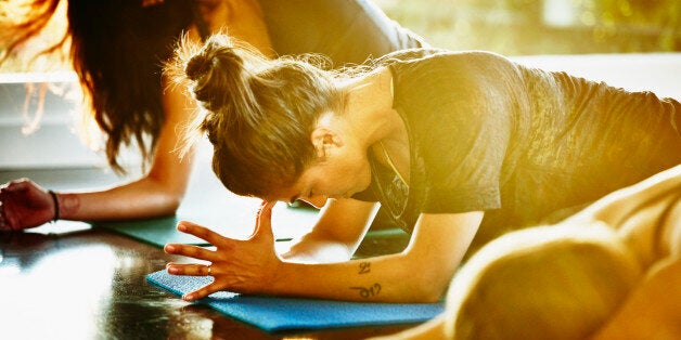 Woman resting between poses in yoga class in studio