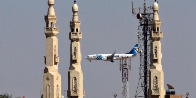 An EgyptAir plane flies past minarets of a mosque as it approaches Cairo International Airport, in Cairo, Egypt, Saturday, May, 21, 2016. Smoke was detected in multiple places on EgyptAir flight 804 moments before it plummeted into the Mediterranean last Thursday, but the cause of the crash that killed all 66 on board remains unclear, the French air accident investigation agency said on Saturday. (AP Photo/Amr Nabil)