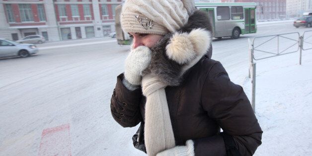 A Russian girl covers her face to ward of the below freezing temperatures in the Siberian city of Novosibirsk on February 10, 2010. AFP PHOTO / VALERY TITIEVSKY (Photo credit should read VALERY TITIEVSKY/AFP/Getty Images)