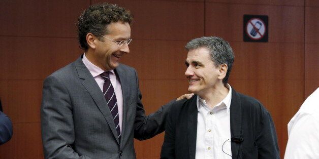 Dutch Finance Minister and Eurogroup President Jeroen Dijsselbloem shakes hands with Greek Finance Minister Euclid Tsakalotos (R) at the start of a euro zone finance ministers meeting in Brussels, Belgium, August 14, 2015. Euro zone finance ministers will discuss whether to agree a third bailout package for Greece on Friday at their meeting in Brussels after the Greek parliament voted to approve the terms. REUTERS/Francois Lenoir