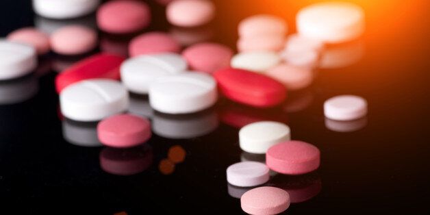 Group of different colorful tablets on black background with reflection