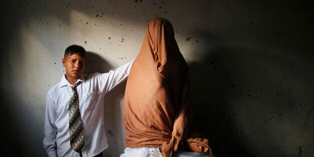 Young Palestinian groom Ahmed Soboh, 15 and his bride Tala, 14, stand inside Tala's house which was damaged during an Israeli strike in 2009, during their wedding party in the town of Beit Lahiya, near the border between Israeli and northern Gaza Strip September 24, 2013. REUTERS/Mohammed Salem (GAZA - Tags: CIVIL UNREST SOCIETY POLITICS)