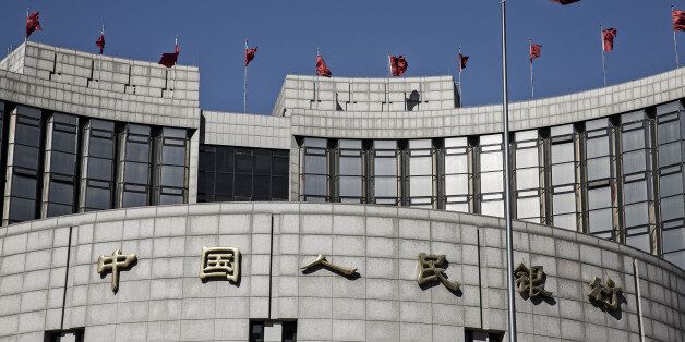 A Chinese national flag flies above the People's Bank of China (PBOC) headquarters in Beijing, China, on Monday, March 7, 2016. Chinese small-cap stocks rallied after Premier Li Keqiang failed to mention a planned shift to a more market-based system for initial public offerings, a reform seen luring funds from existing equities. Photographer: Qilai Shen/Bloomberg via Getty Images