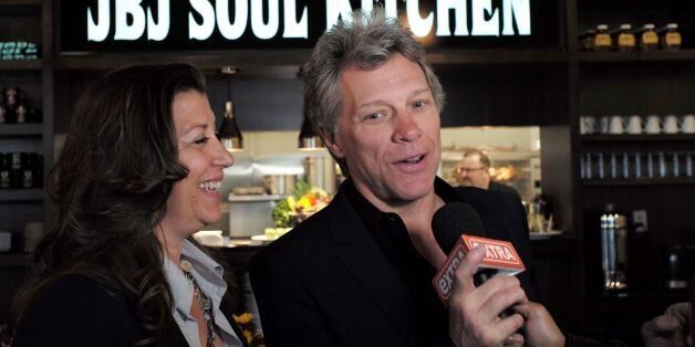 US signer Jon Bon Jovi and his wife Dorothea speak to the media after opening the BEAT (Bringing Everyone All Together) center in Toms River, New Jersey, on May 10, 2016.The Food Bank of Monmouth and Ocean Counties, Jon Bon Jovi Soul Foundation and Peoples Pantry announced the opening of BEAT, a place where families and individuals can access food, job training and resources to help end the cyclical causes of hunger in Ocean county. / AFP / Jewel SAMAD (Photo credit should read JEWEL SAMAD/AFP/Getty Images)