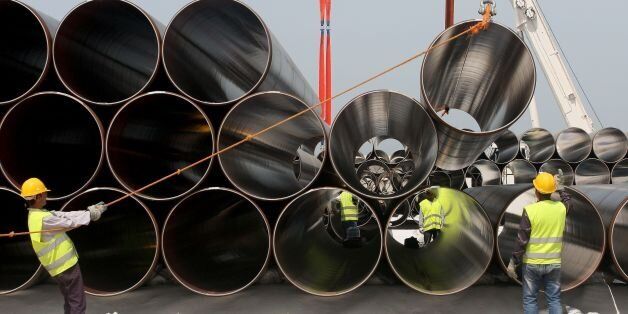 Workers unload newly arrived pipes for the construction of the future Trans-Adriatic Pipeline in Spitalle, near Durres, on April 18, 2016, aimed to bring gas from the Caspian Sea to Europe.The 867 km pipeline will cross through Greece, Albania, offshore under the Adriatic Sea, before reaching Italy. / AFP / GENT SHKULLAKU (Photo credit should read GENT SHKULLAKU/AFP/Getty Images)