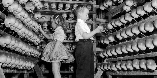 A young boy and girl inspecting dolls' heads at the Ideal Toy Company in Jamaica, Long Island, USA. The company is one of the largest toy manufacturers in the world.