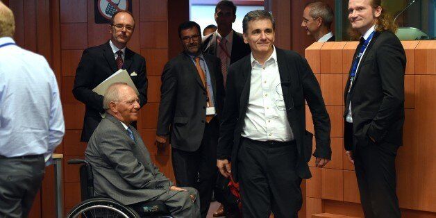 German Finance Minister Wolfgang Schauble (CL) and Greece's Finance Minister Euclid Tsakalotos (CR) attend an extraordinary Eurogroup meeting on Greece at the European Council in Brussels, on August 14, 2015. Eurozone finance ministers are scheduled to meet to go over a new bailout programme in return for reforms by Greece, but some of the creditors feel Athens' pledges are not precise enough. AFP PHOTO/Emmanuel Dunand (Photo credit should read EMMANUEL DUNAND/AFP/Getty Images)
