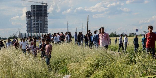 People stay behind a police cordon near the site where a bomb exploded on May 10, 2016 in Diyarbakir.Three people, including police, were killed and 22 others wounded when a car bomb attack blamed on Kurdish militants struck a police vehicle in the southeastern city of Diyarbakir, reports said. / AFP / ILYAS AKENGIN (Photo credit should read ILYAS AKENGIN/AFP/Getty Images)