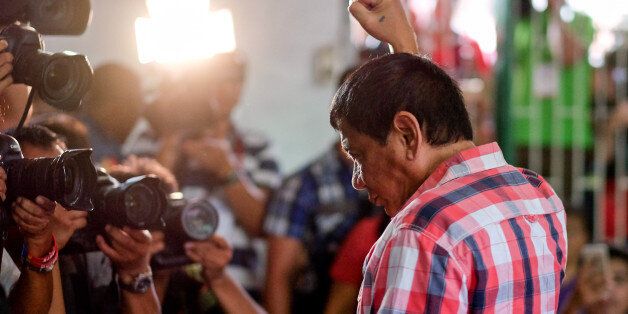 Rodrigo Duterte, Mayor of Davao and presidential candidate, gestures to members of the media at a polling station during the presidential election in Davao, Mindanao, the Philippines on Monday, May 9, 2016. Filipinos began voting in a holly contested presidential election that's seen Rodrigo Duterte, the controversial mayor of Davao City, propelled to the front of the pack with his tough talk to combat crime and deal with traffic-clogged roads in the Philippines. Photographer: Veejay Villafranca/Bloomberg via Getty Images