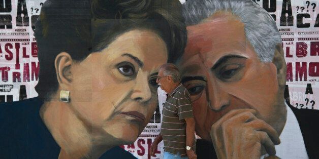 A man walks past a mural depicting Brazilian President Dilma Rousseff (L) and Vice-President Michel Temer at Paulista Avenue in Sao Paulo, Brazil on April 19, 2016.Brazil woke Monday to deep political crisis after lawmakers authorized impeachment proceedings against President Dilma Rousseff, sparking claims that democracy was under threat in Latin America's biggest country. / AFP / NELSON ALMEIDA (Photo credit should read NELSON ALMEIDA/AFP/Getty Images)