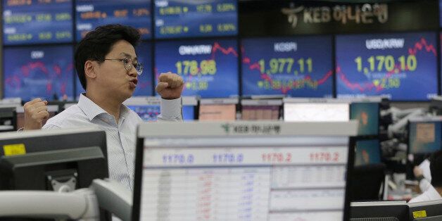 A currency trader gestures at the foreign exchange dealing room of the KEB Hana Bank headquarters in Seoul, South Korea, Wednesday, May 11, 2016. Asian stock markets were uneven on Wednesday as the price of oil fell and concerns about Chinese recovery weighed. (AP Photo/Ahn Young-joon)