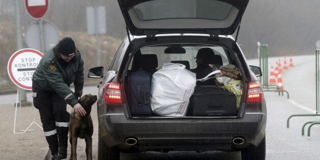 A Lithuanian border guard with a dog performs check on a car at a checkpoint at the border with Latvia near Zarasai, Lithuania, March 8, 2016. Estonia, Latvia and Lithuania are tightening ID controls and erecting fences on their eastern borders, worried the Baltic region will become a new entry point for refugees as migrant routes through the Balkans becomes harder. REUTERS/Ints Kalnins