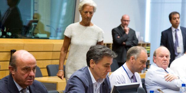 Managing Director of the International Monetary Fund Christine Lagarde, center left, prepares to speak with Greek Finance Minister Euclid Tsakalotos, sitting second left, during a meeting of eurozone finance ministers at the EU Lex building in Brussels on Saturday, July 11, 2015. Greece's negotiators head to Brussels on Saturday armed with their reform proposals and parliamentary backing to seek a third bailout, but with the shadow of severe dissent from governing lawmakers hanging over them. (A