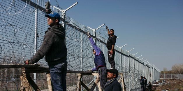 Workers attach barbed wire to a border fence to prevent illegal crossings by migrants at the Bulgarian-Turkish border near the Bulgarian village of Shtit on March 18, 2016. EU leaders approved a controversial deal with Turkey to curb the huge flow of asylum seekers to Europe, with all migrants arriving in Greece from March 13, 2016 to be sent back. / AFP / DIMITAR DILKOFF (Photo credit should read DIMITAR DILKOFF/AFP/Getty Images)
