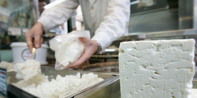 A cheesemonger puts pieces of Greece's trademark feta cheese in a bag for a customer in central Athens November 21, 2007. Greece has declared war on white cheeses, launching 2008 as the