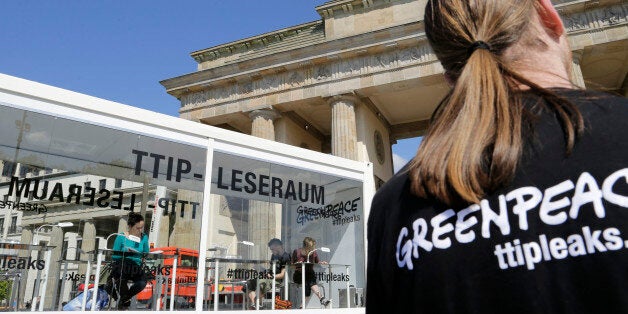 People read documents on the Trans-Atlantic talks to create a massive free trade zone between the United States and the European Union in a 'TTIP reading room' set up by Greenpeace in front of the Brandenburg Gate in Berlin, Germany, Monday, May 2, 2016. Greenpeace released confidential negotiating texts that the environmental group claims shows U.S. ill intent. (AP Photo/Ferdinand Ostrop)