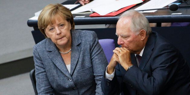 German Chancellor Angela Merkel, left, talks to Finance Minister Wolfgang Schaeuble during a debate at the German parliament prior to a vote on another bailout package for Greece, in the German Bundestag in Berlin, Wednesday, Aug. 19, 2015. (AP Photo/Markus Schreiber).