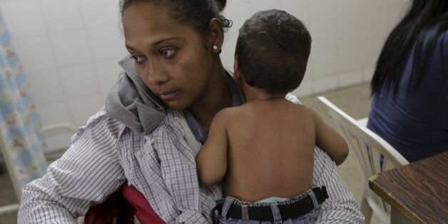 A woman who suspects her child to be infected with Zika virus, holds him as they wait at the emergency room in a hospital at the Petare slum in Caracas, Venezuela February 4, 2016. REUTERS/Marco Bello