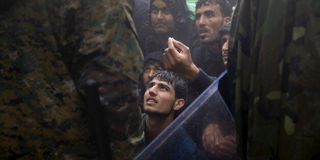 Migrants and refugees beg Macedonian policemen to allow passage to cross the border from Greece into Macedonia during a rainstorm, near the Greek village of Idomeni, September 10, 2015. Reuters and The New York Times shared the Pulitzer Prize for breaking news photography for images of the migrant crisis in Europe and the Middle East. REUTERS/Yannis Behrakis TPX IMAGES OF THE DAY