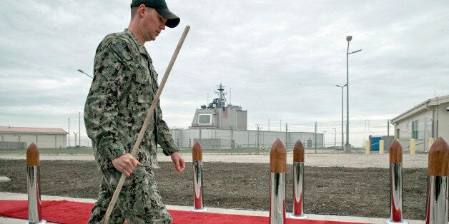 A US serviceman, backdropped by the radar building of a missile defense base, carries a mop in Deveselu, prior to an opening ceremony attended by U.S., NATO and Romanian officials at a base, originally established by the Soviet Union, in Deveselu, Southern Romania, Thursday, May 12, 2016. A U.S missile defense site in Romania aimed at protecting Europe from ballistic missile threats became operational Thursday, angering Russia which opposes having the advanced military system in its former area of influence.(AP Photo/Vadim Ghirda)