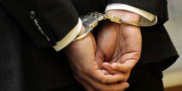 The handcuffed hands of Magnus Gaefgen are seen prior to the start of his trial against the state of Hesse at the country court in Frankfurt, March 17, 2011. Gaefgen, who was convicted for murdering 10 year old Jakob von Metzler in 2002 impeaches Hesse's authorities on torture and demands 15000 euros of compensation. REUTERS/Kai Pfaffenbach (GERMANY - Tags: CRIME LAW)
