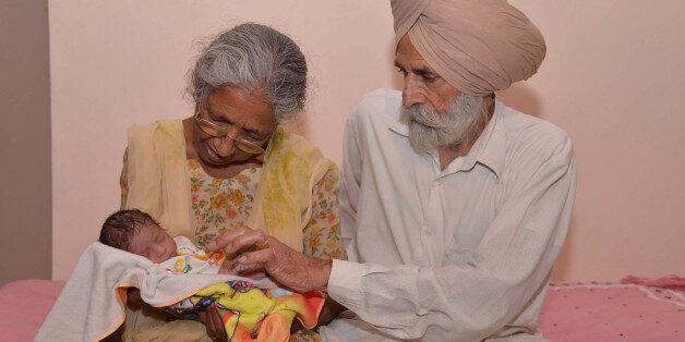 Indian father Mohinder Singh Gill, 79, and his wife Daljinder Kaur, 70, pose for a photograph as they hold their newborn baby boy Arman at their home in Amritsar on May 11, 2016.An Indian woman who gave birth at the age of 70 said May 10 she was not too old to become a first-time mother, adding that her life was now complete. Daljinder Kaur gave birth last month to a boy following two years of IVF treatment at a fertility clinic in the northern state of Haryana with her 79-year-old husband. / AFP / NARINDER NANU (Photo credit should read NARINDER NANU/AFP/Getty Images)