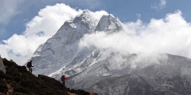 In this March 5, 2016 photo, trekkers hike at the base of Mount Ama Dablam (6856 meters) in the Khumbu region of Nepal. (AP Photo/Tashi Sherpa)