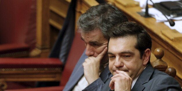Greek Prime Minister Alexis Tsipras (R) sits next to Finance Minister Euclid Tsakalotos (L) as he attends a parliamentary session in Athens, Greece July 16, 2015. Tsipras battled to win lawmakers' approval on Wednesday for a bailout deal to keep Greece in the euro, while the country's creditors, pressed by the IMF to provide massive debt relief, struggled to agree a financial lifeline. REUTERS/Christian Hartmann