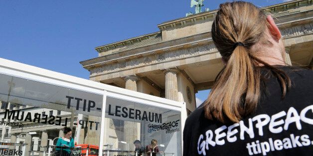 People read documents on the Trans-Atlantic talks to create a massive free trade zone between the United States and the European Union in a 'TTIP reading room' set up by Greenpeace in front of the Brandenburg Gate in Berlin, Germany, Monday, May 2, 2016. Greenpeace released confidential negotiating texts that the environmental group claims shows U.S. ill intent. (AP Photo/Ferdinand Ostrop)