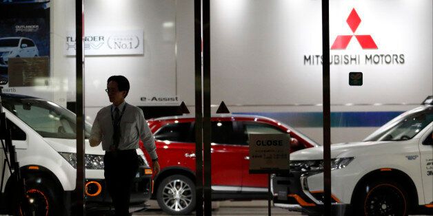TOKYO, JAPAN - APRIL 20: An employee walks past a Mitsubishi Motors vehicles displayed at the company's headquarters on April 20, 2016 in Tokyo, Japan. Mitsubishi Motors share plunged more than 15% after the Japanese car maker announced it has mishandled the fuel economy test data. (Photo by Tomohiro Ohsumi/Getty Images)