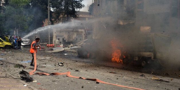 In this photo released by the Syrian official news agency SANA, Syrian citizens and firefighters gather at the scene where one of rockets hit the Dubeet hospital in the central neighborhood of Muhafaza in Aleppo, Syria, Tuesday, May 3, 2016. Shells and mortar rounds are raining down on every neighborhood Aleppo,