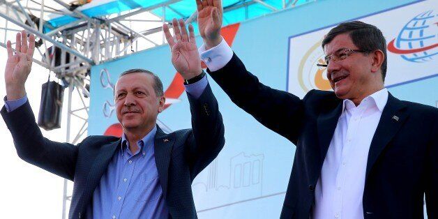 ANTALYA, TURKEY - APRIL 22: Turkish President Recep Tayyip Erdogan (L) raises his hands with the Rabia gestures as Prime Minister Ahmet Davutoglu (R) waves his hands during an opening ceremony in Kepez district of Antalya, Turkey on April 22, 2016. (Photo by Kayhan Ozer/Anadolu Agency/Getty Images)
