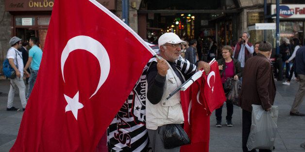 ISTANBUL, TURKEY - MAY 03: A man sells Turkish flags on the street outside the Eminonu Mosque on May 3, 2016 in Istanbul Turkey. The European Commission is expected to recommend granting Turks with visa free travel in Europe's Schengen area, as part of the EU-Turkey migrant deal on Wednesday. EU member states and the European Parliament are set to vote on the visa deal in June, which could see visa free travel granted to Turkish citizens as early as the end of June. (Photo by Chris McGrath/Getty Images)