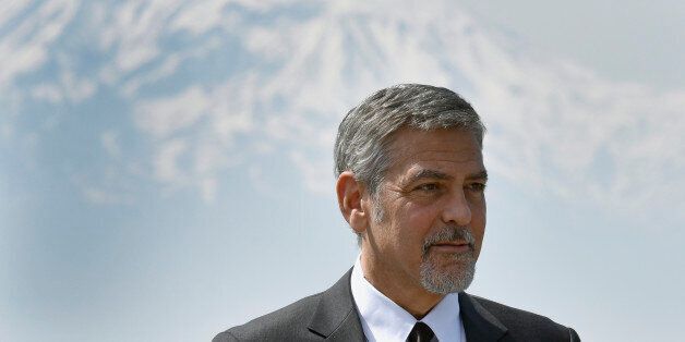 US actor George Clooney poses with Ararat mountain in background, as he attends a ceremony at the Armenian Genocide Memorial in Yerevan on April 24, 2016.Hollywood star and rights advocate George Clooney led thousands of Armenians on a march to a hilltop memorial in Yerevan to commemorate the 101st anniversary of the WW I-era Armenian genocide in the Ottoman Empire. / AFP / KAREN MINASYAN (Photo credit should read KAREN MINASYAN/AFP/Getty Images)