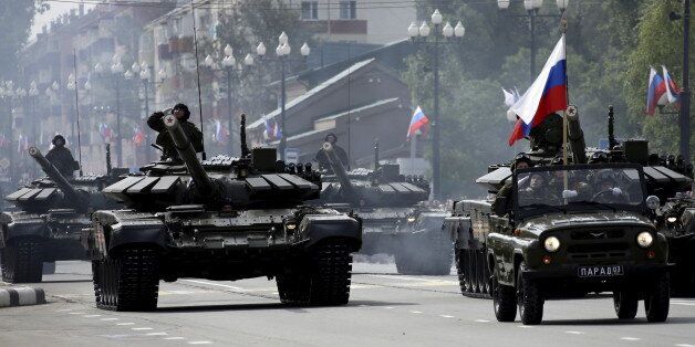 Russian servisemen drive T-72 main battle tanks during a parade to mark the 70th anniversary of the end of the World War Two in the Far Eastern city of Yuzhno-Sakhalinsk, Russia, September 2, 2015. Russia staged a military parade on Wednesday to commemorate seizing a group of Pacific islands from Japan at the end of World War Two, a move likely to inflame tensions over a long-running territorial dispute with Tokyo. The show of force, the first of its kind on the island of Sakhalin in Russia's Far East, is part of a push by President Vladimir Putin to showcase his country's military might at a time when ties with the West are strained over the Ukraine crisis. REUTERS/Sergei Krasnoukhov